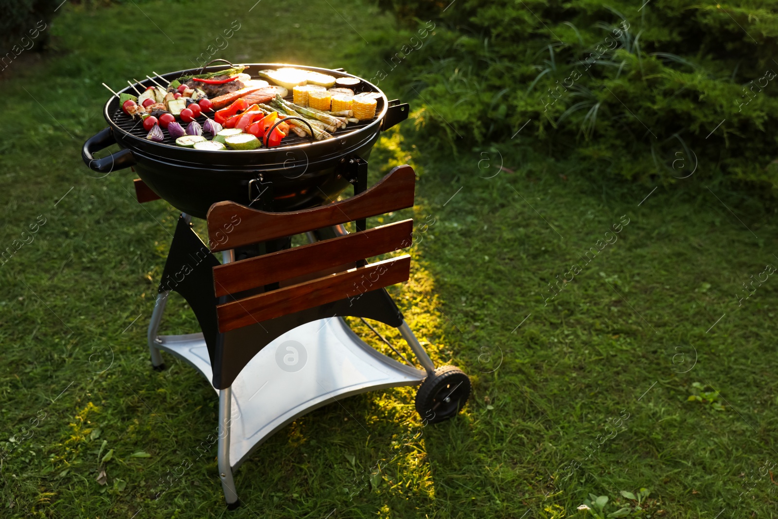 Photo of Delicious grilled vegetables on barbecue grill outdoors. Space for text