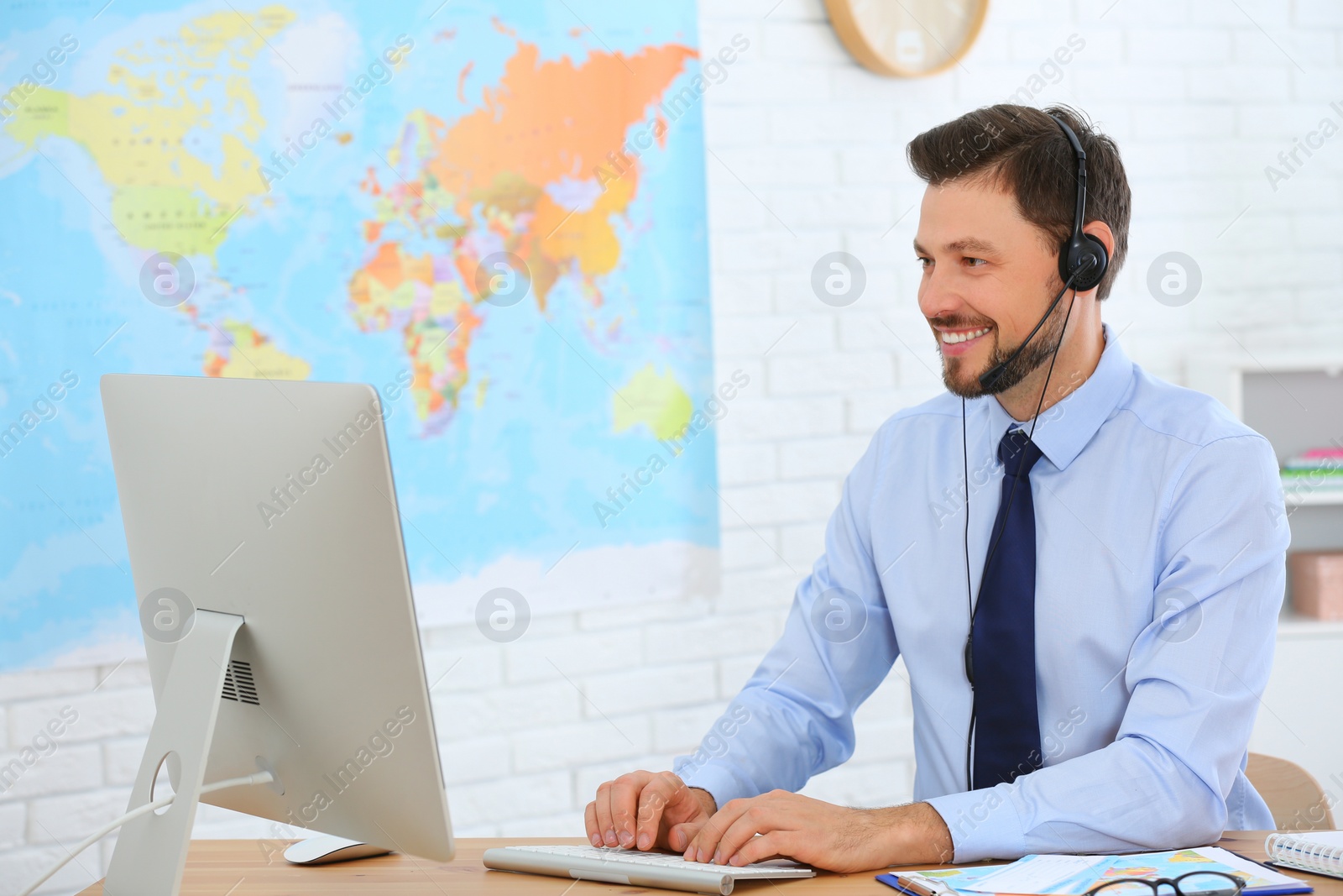 Photo of Male consultant working with computer in travel agency