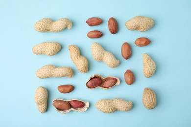 Fresh peanuts on light blue table, flat lay