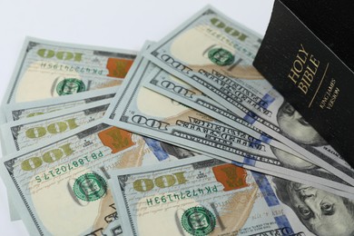 Photo of Holy Bible with money on white background, closeup