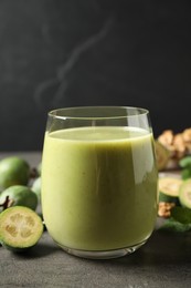 Photo of Fresh feijoa smoothie in glass on grey table