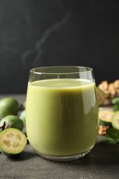 Fresh feijoa smoothie in glass on grey table