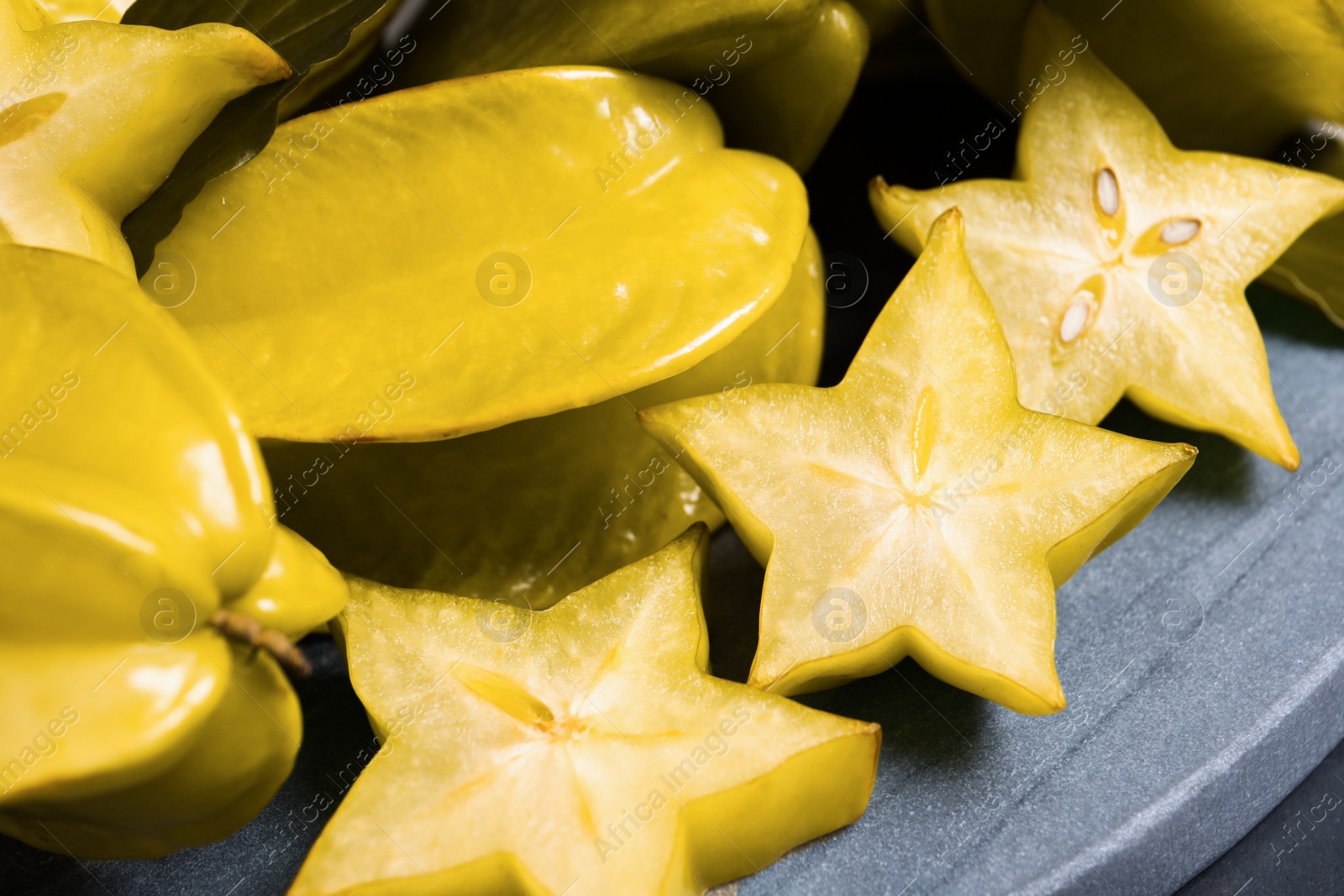 Photo of Cut and whole carambolas on board, closeup