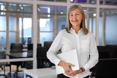 Photo of Smiling woman with laptop in office, space for text. Lawyer, businesswoman, accountant or manager