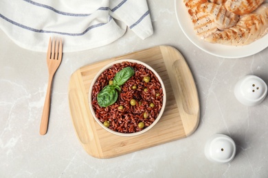 Photo of Flat lay composition with delicious cooked brown rice on white marble table