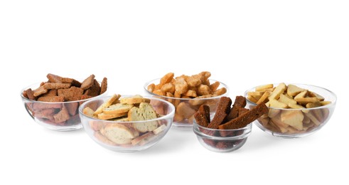 Different crispy rusks in bowls on white background