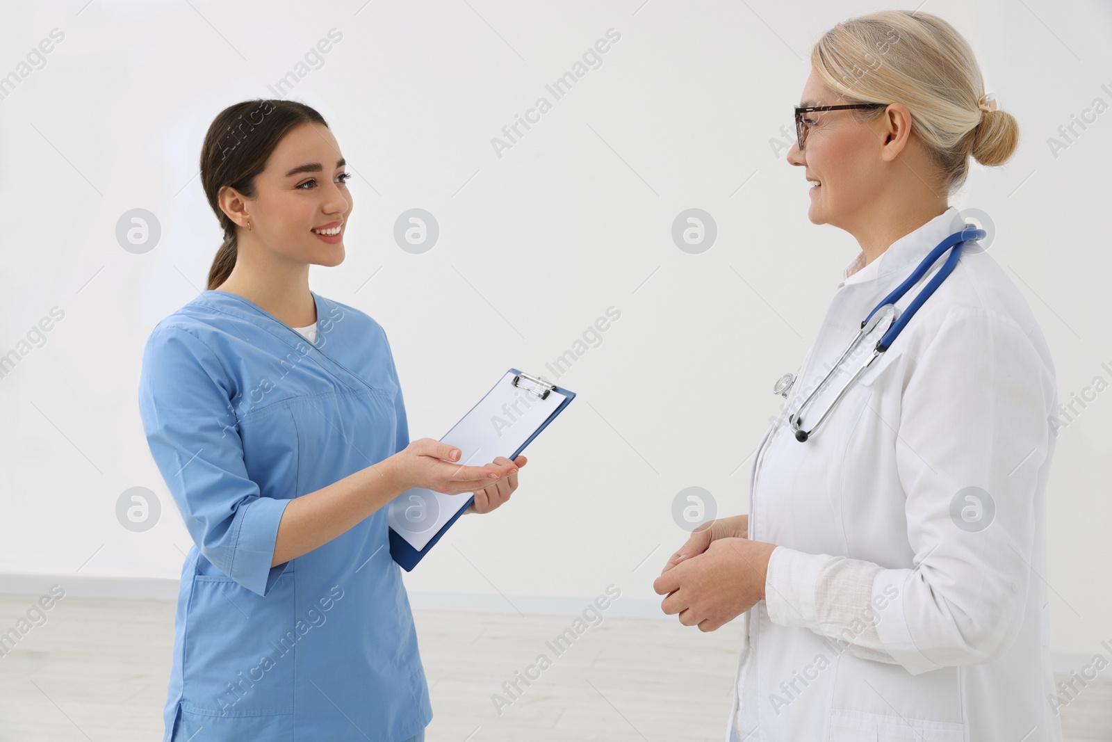 Photo of Medical doctors in uniforms having discussion indoors