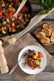 Photo of Delicious ratatouille served on wooden table, flat lay