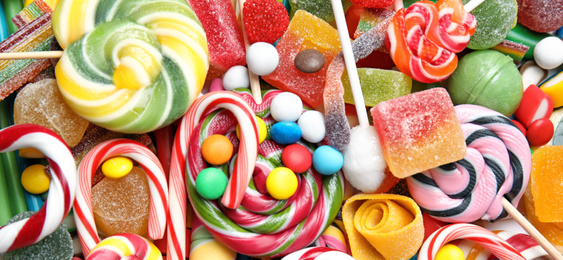 Many different yummy candies as background, top view. Banner design 