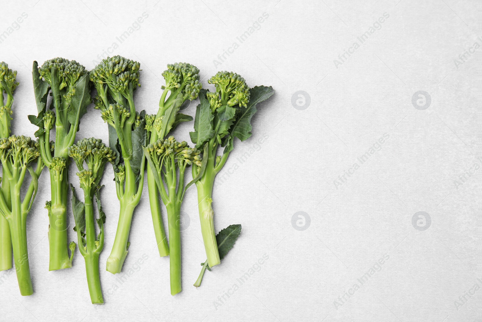 Photo of Fresh raw broccolini on white background, flat lay and space for text. Healthy food