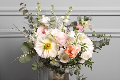 Bouquet of beautiful flowers near light wall, closeup