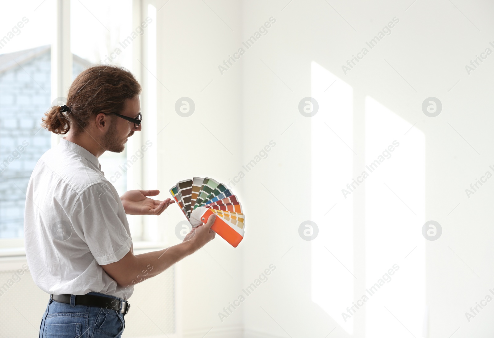 Photo of Professional interior designer with color palette in empty apartment. Space for text