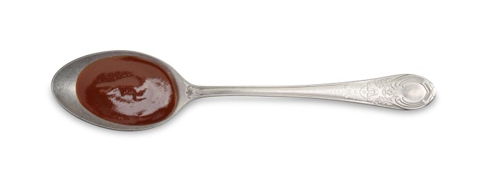 Tasty barbecue sauce in spoon isolated on white, top view