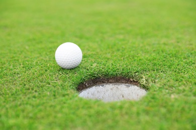 Photo of Golf ball near hole on green course