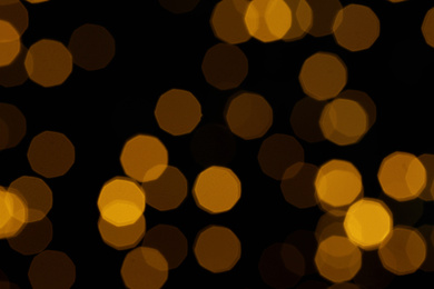 Blurred view of beautiful lights on black background. Bokeh effect