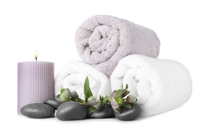 Photo of Composition with towels and spa stones isolated on white