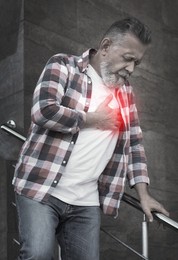 Image of Mature man having heart attack outdoors. Emergency help