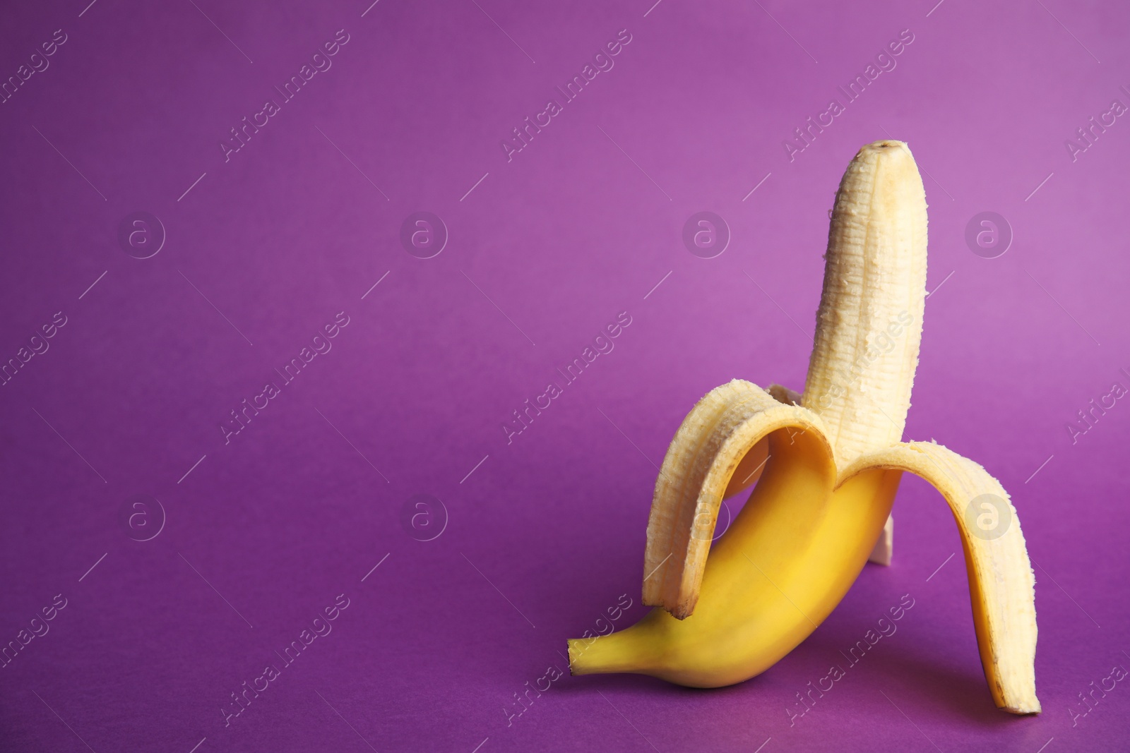 Photo of Fresh banana on purple background, space for text. Sex concept