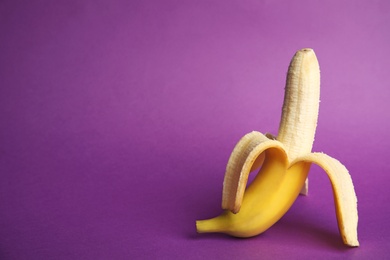 Fresh banana on purple background, space for text. Sex concept