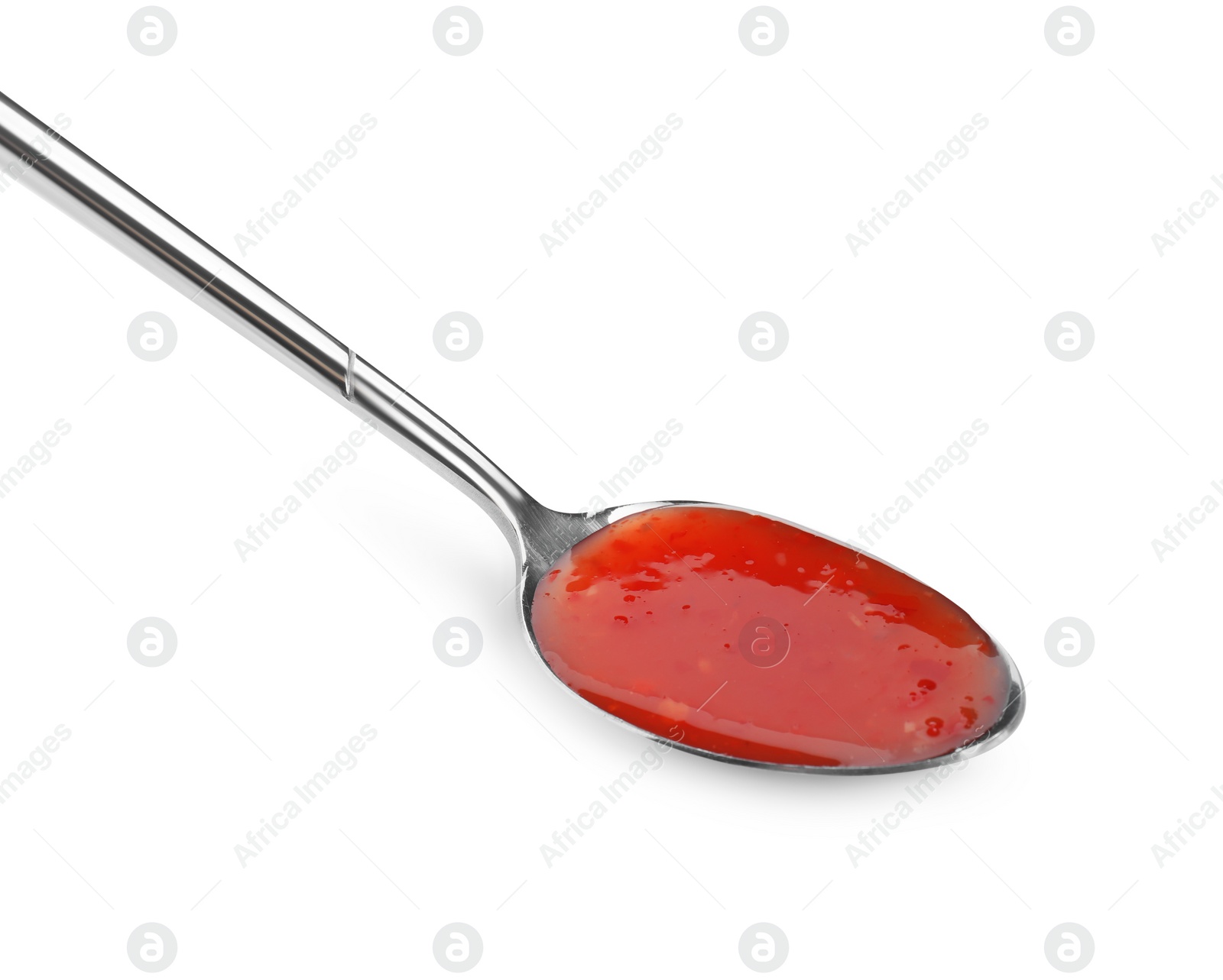 Photo of Spicy chili sauce in spoon isolated on white