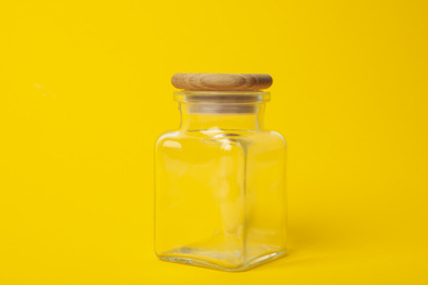 Photo of Closed empty glass jar on yellow background