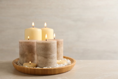 Plate with different candles and rocks on table, space for text