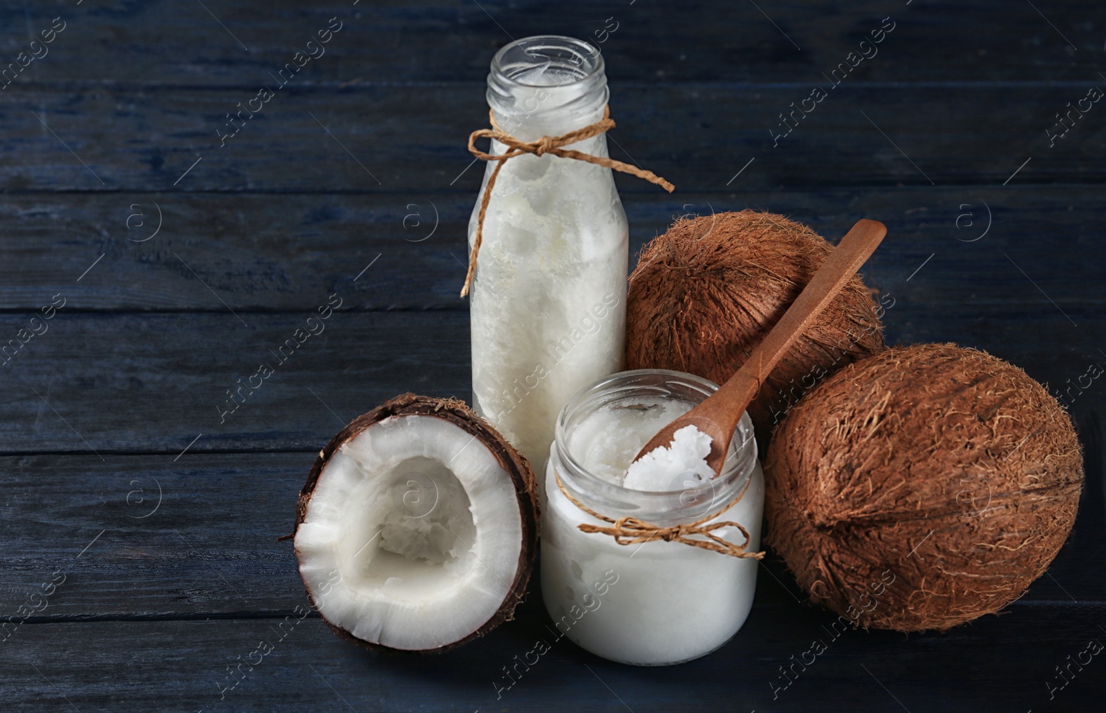 Photo of Fresh coconut oil on dark wooden table. Cooking ingredient