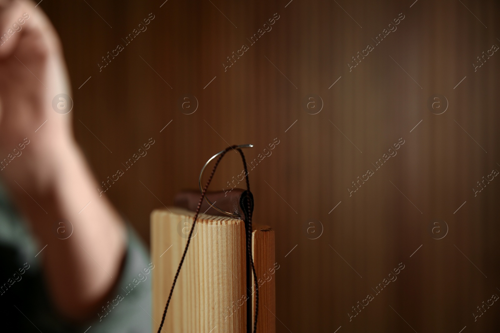 Photo of Piece of leather with needle and thread, closeup