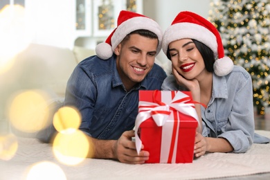 Photo of Happy couple with Christmas gift box at home