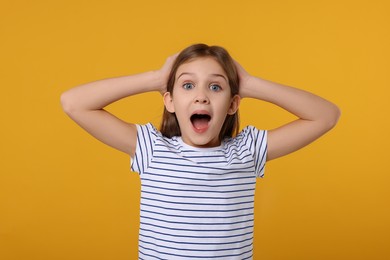 Portrait of surprised girl on yellow background