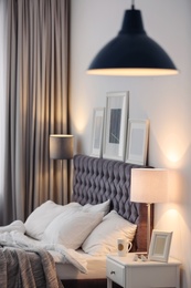 Photo of Modern room interior with comfortable bed and stylish lamp