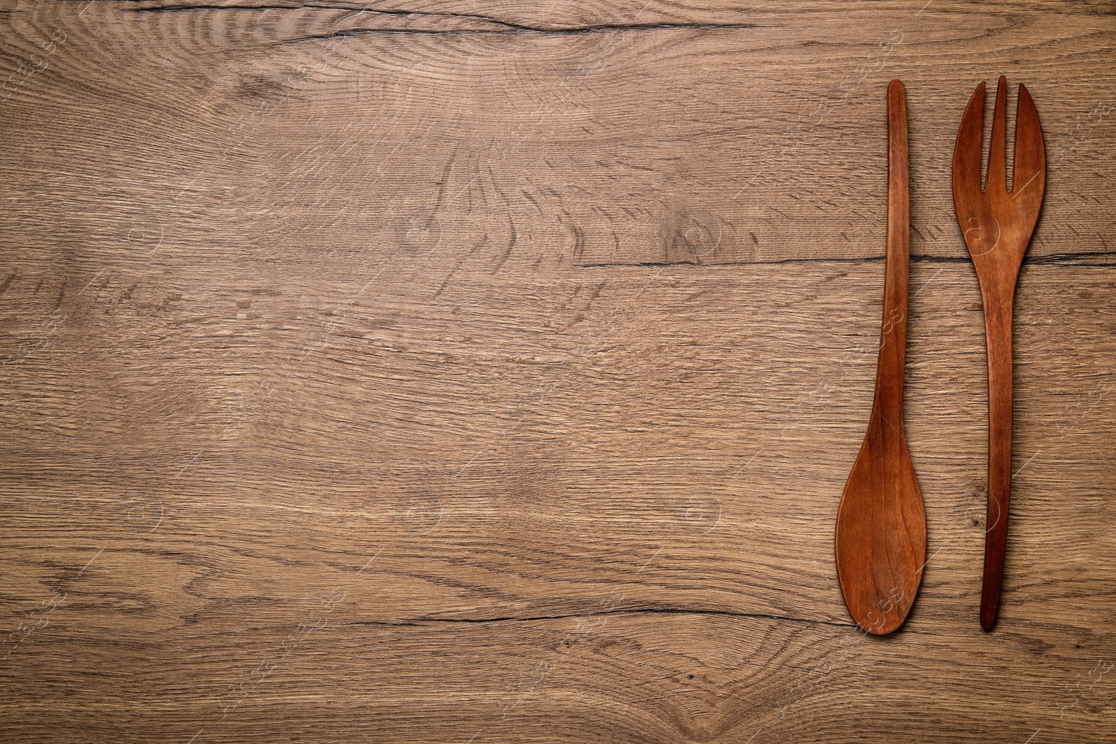 Photo of Wooden spoon and fork on table, flat lay with space for text. Cooking utensils
