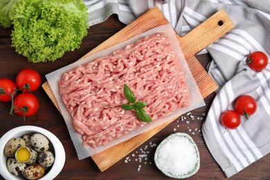 Photo of Raw chicken minced meat and ingredients on wooden table, flat lay