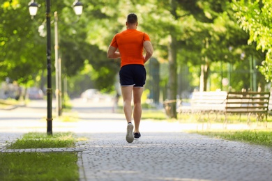 Photo of Young man running in park on sunny day