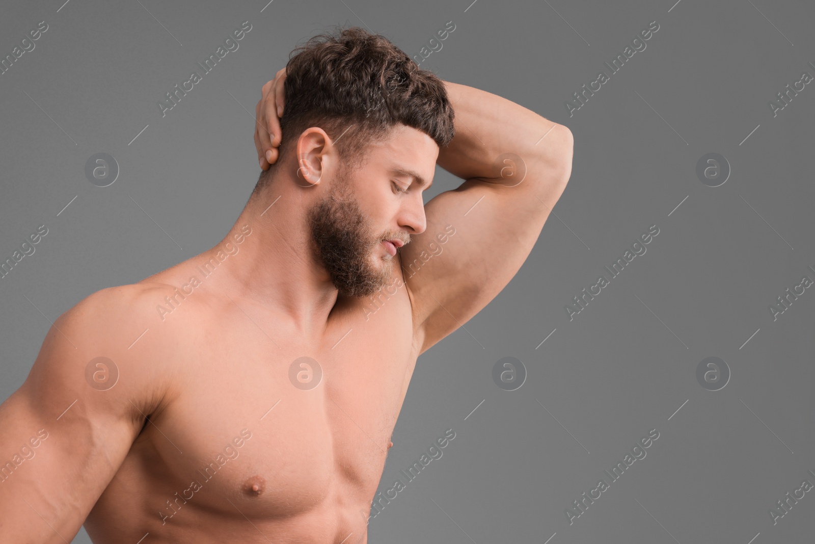 Photo of Handsome muscular man on grey background, space for text. Sexy body