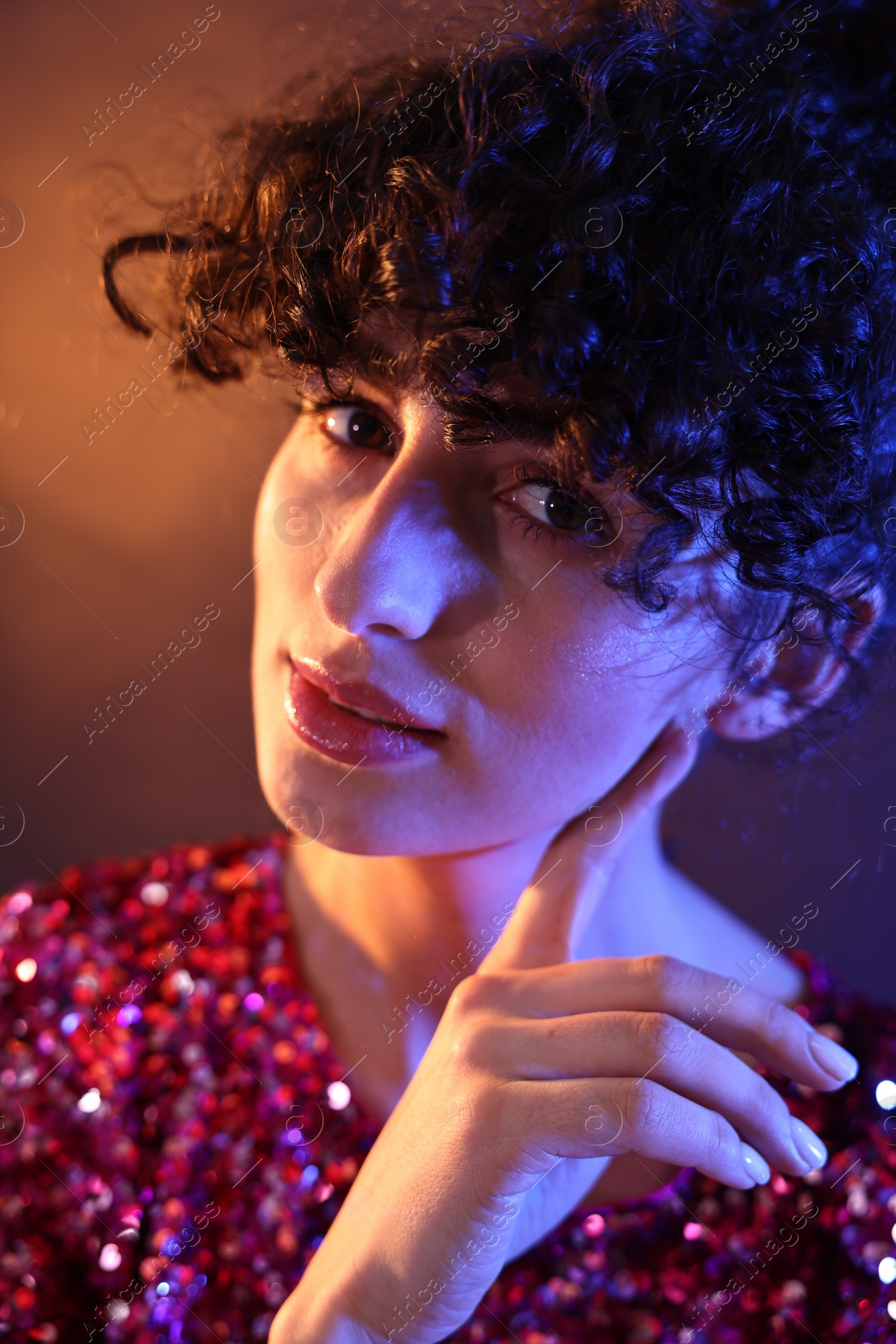 Photo of Beautiful young woman posing on color background in neon lights