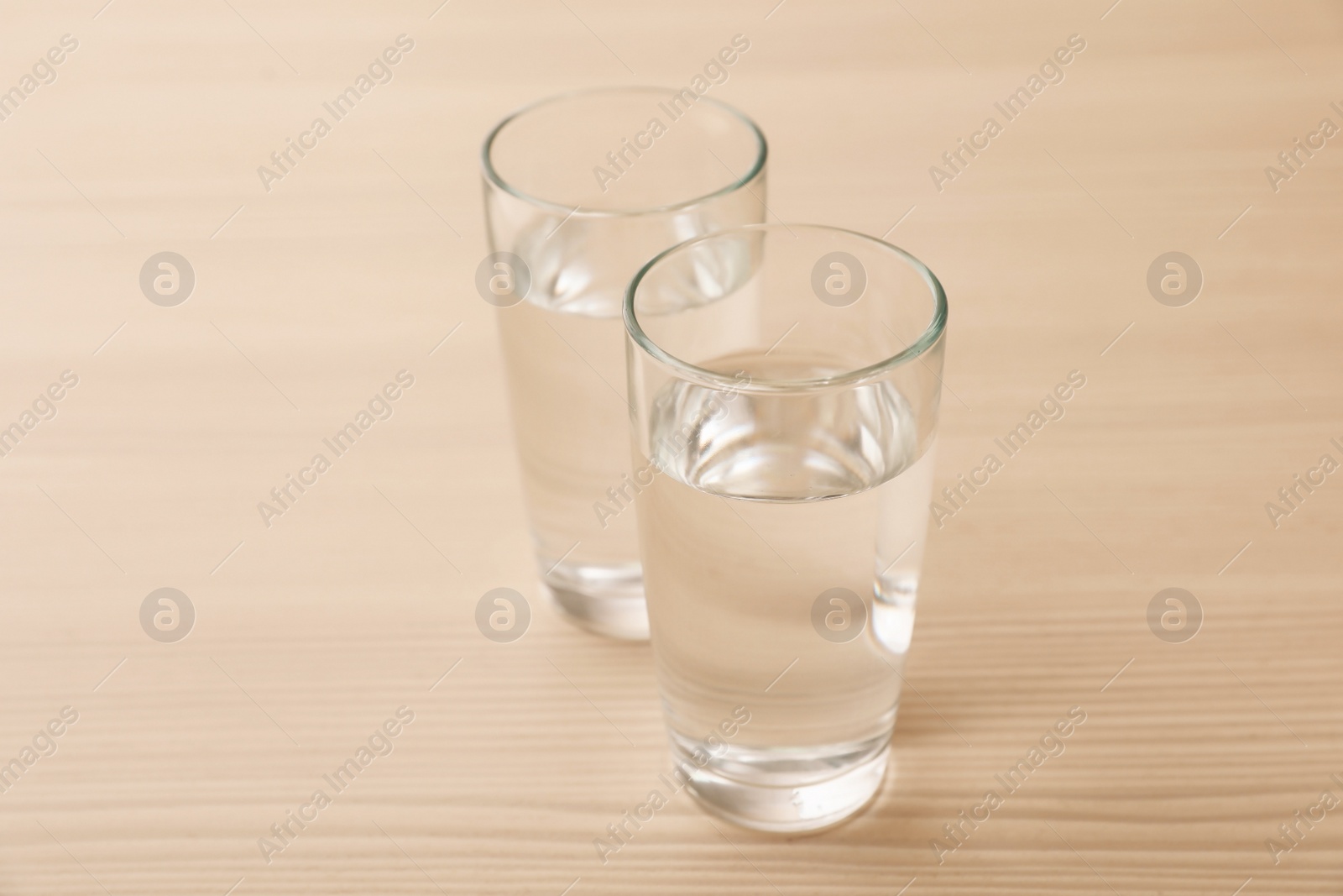 Photo of Glasses of fresh water on wooden table