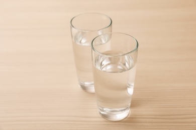 Glasses of fresh water on wooden table