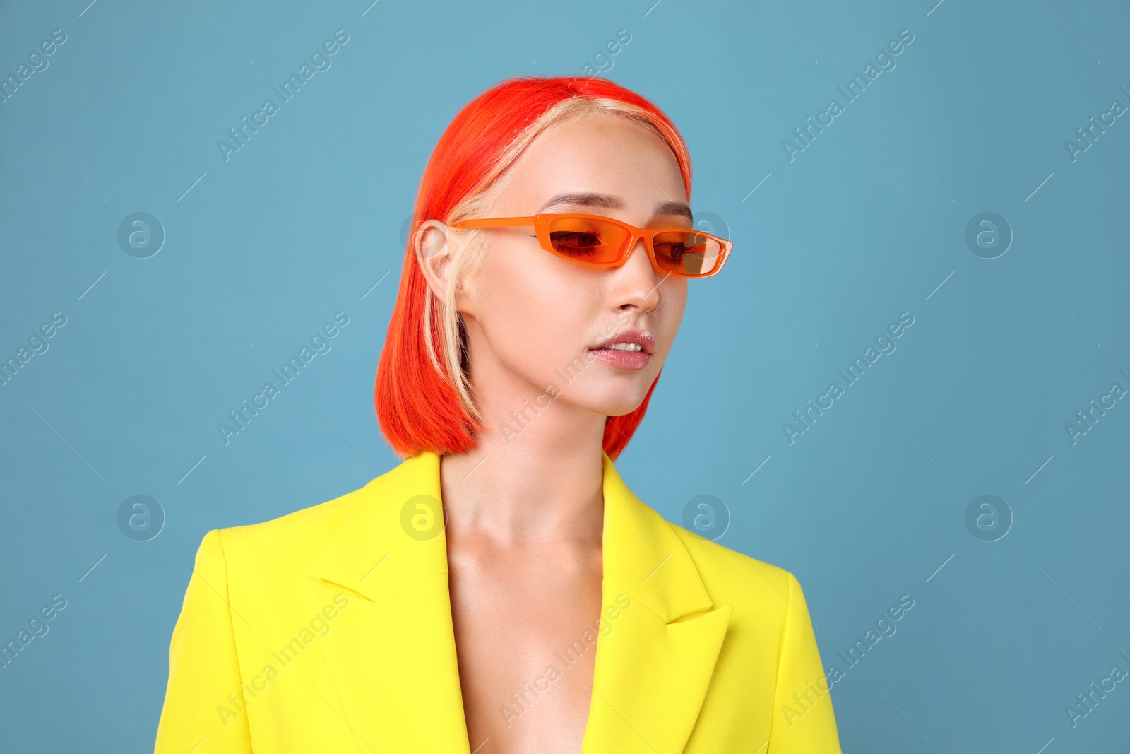 Photo of Beautiful young woman with bright dyed hair on turquoise background