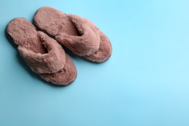 Photo of Pair of stylish soft slippers on light blue background, flat lay. Space for text