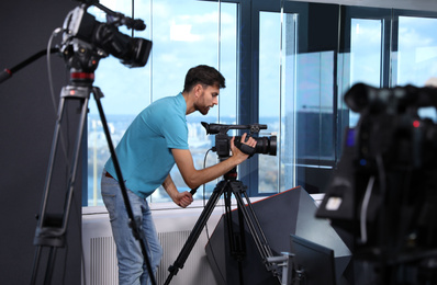 Photo of Professional video camera operator working in studio