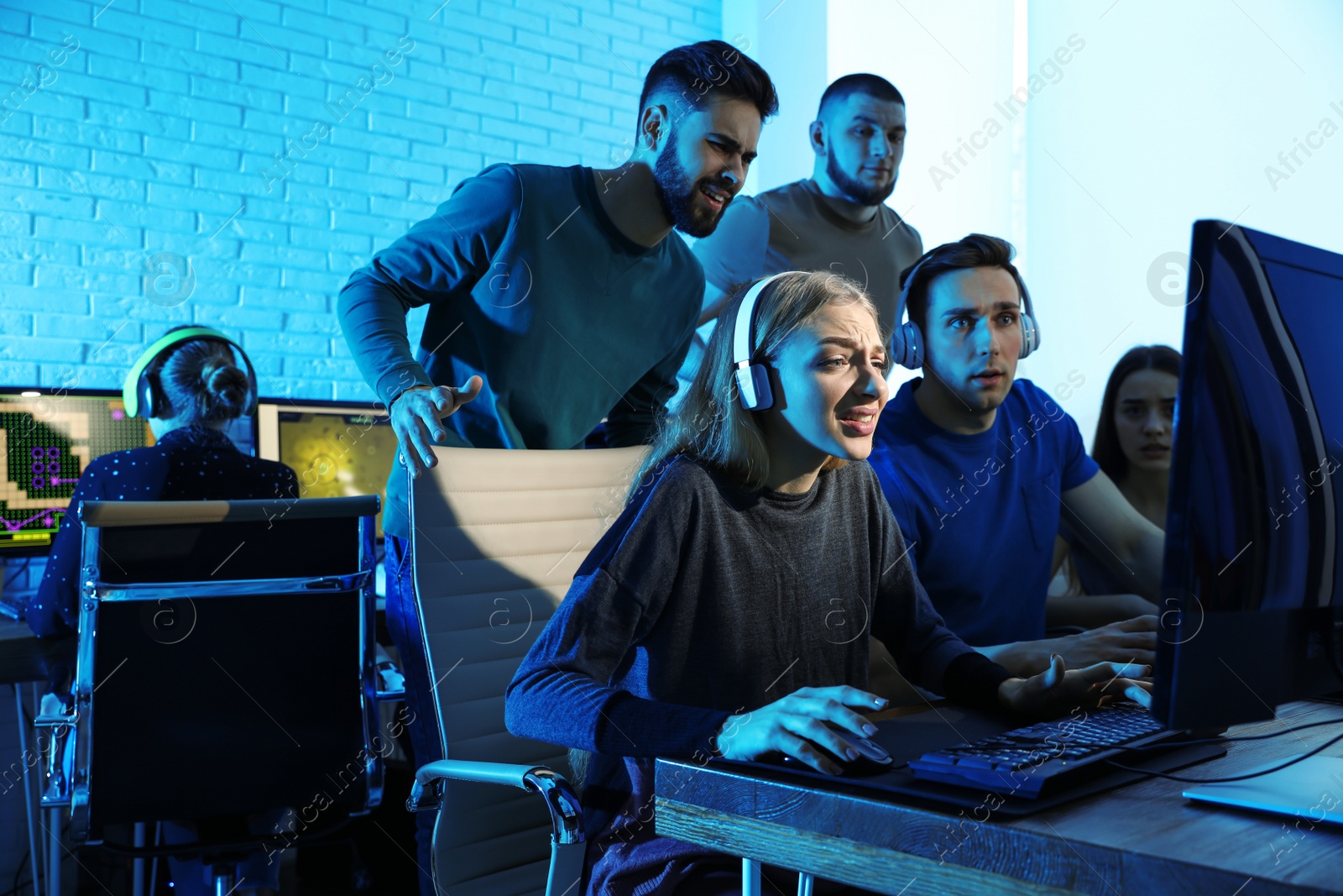 Photo of Young people playing video games on computers indoors. Esports tournament