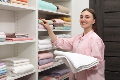 Photo of Happy customer choosing towels in linen shop