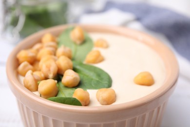 Photo of Tasty chickpea soup in bowl on white table, closeup