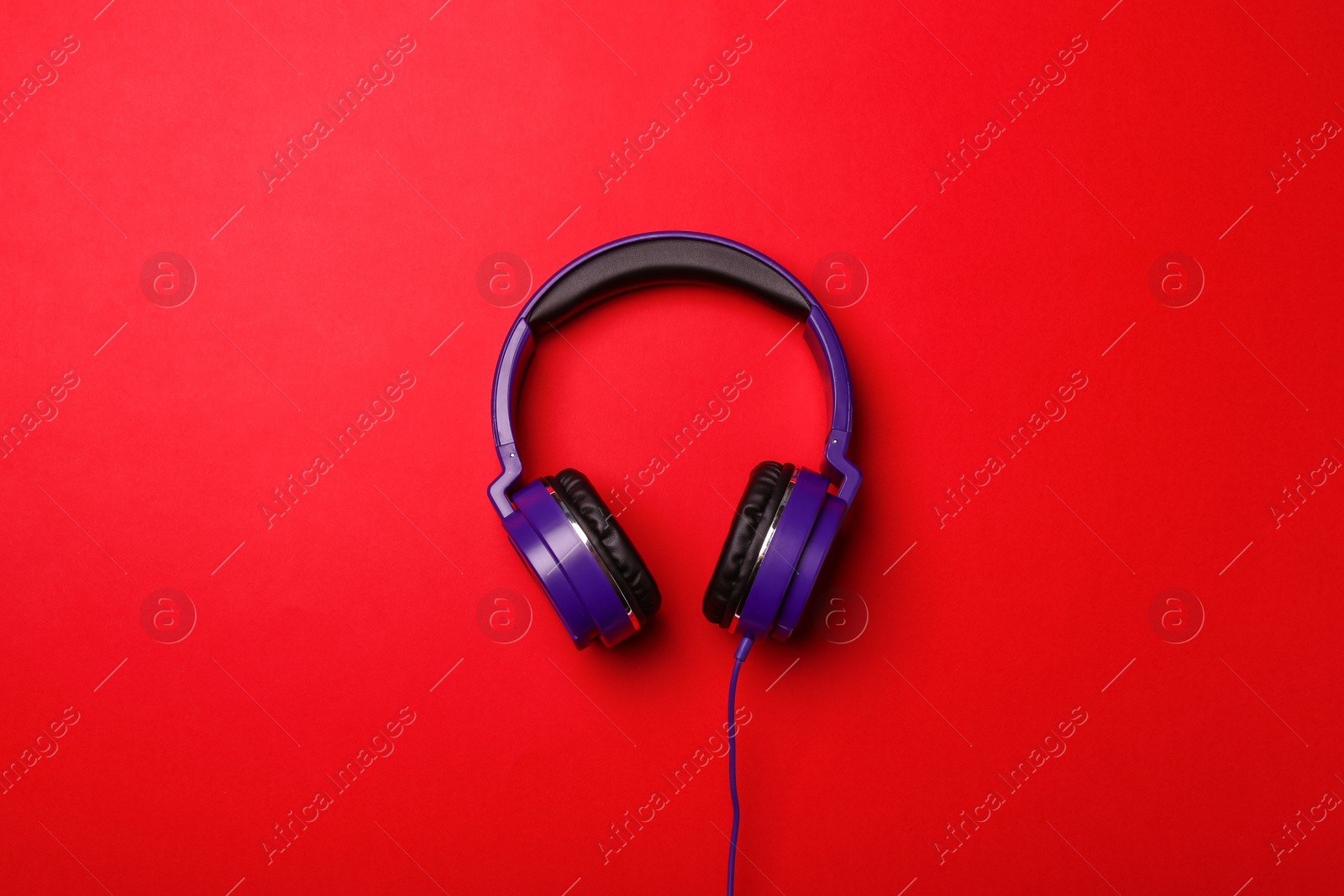Photo of Stylish modern headphones on color background, top view