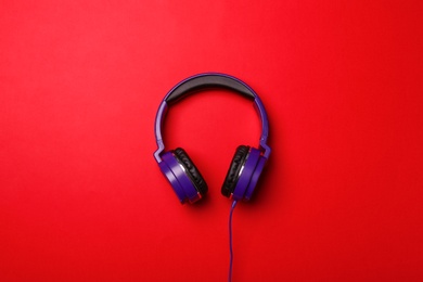 Stylish modern headphones on color background, top view