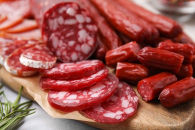 Different types of delicious sausages on light grey table, closeup