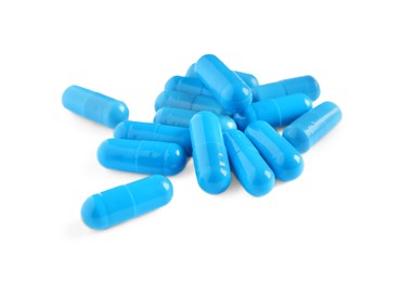 Photo of Pile of blue pills on white background