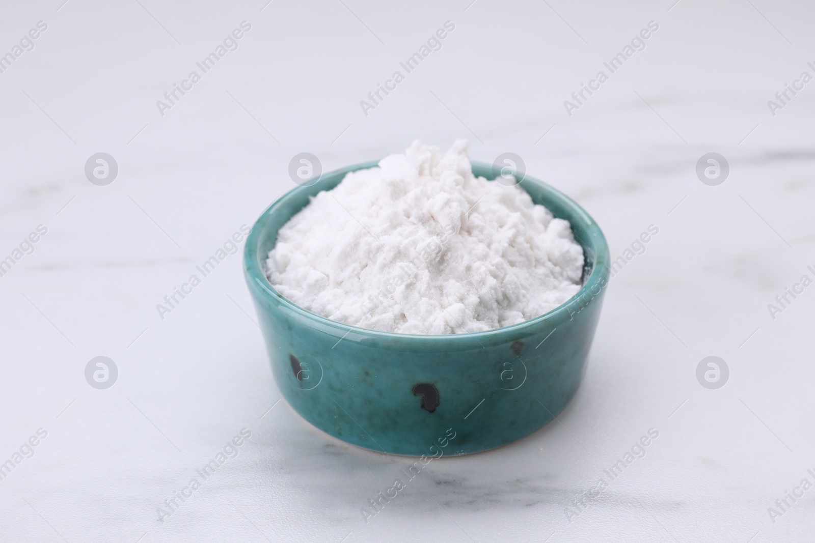 Photo of Bowl of natural starch on white marble table, closeup