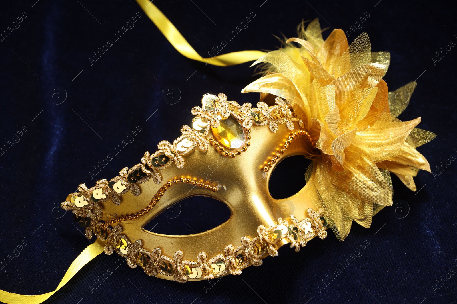 Photo of Theater arts. Golden venetian carnival mask on blue fabric